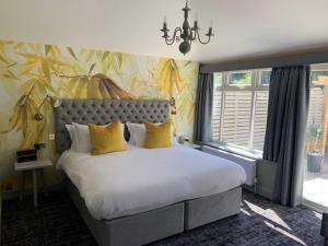 een slaapkamer met een groot bed met gele kussens bij The Old Mill in Lymington