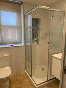 La salle de bains est pourvue d'une douche, de toilettes et d'une fenêtre. dans l'établissement Piso recién reformado, cómodo y muy luminoso., à Ferrol