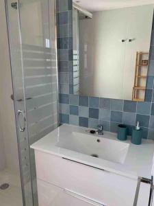 La salle de bains est pourvue d'un lavabo blanc et d'un miroir. dans l'établissement Piso recién reformado, cómodo y muy luminoso., à Ferrol