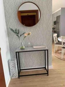 een tafel in een woonkamer met een spiegel bij Piso recién reformado, cómodo y muy luminoso. in Ferrol