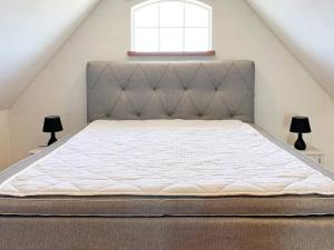 łóżko na poddaszu z dwoma lampami i oknem w obiekcie Holiday home SKIVARP IV w mieście Skivarp