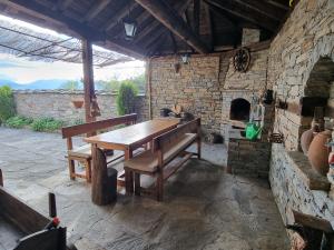 レシテンにあるLeshten Valentin's Houseの石造りの建物内の木製テーブルとベンチ