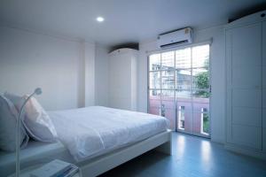 Habitación blanca con cama y ventana en Room 4 Bangkok Center WIFI Netflix, en Bangkok