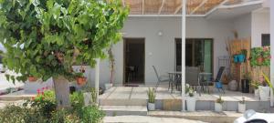 ein weißes Haus mit einem Tisch und einem Baum in der Unterkunft Oasis Nature in Polis Chrysochous