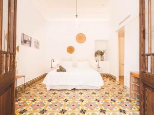 ein Schlafzimmer mit einem weißen Bett und gemustertem Boden in der Unterkunft Hotel Boutique Can Pocovi in Sant Llorenç des Cardassar