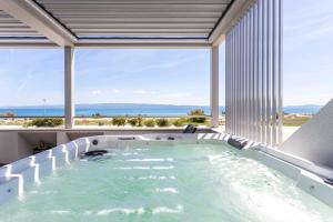 a jacuzzi tub with a view of the ocean at Apartments Blue Maris Žnjan in Split