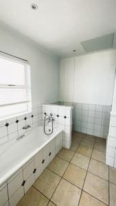 a white bathroom with a tub and a window at Luxury Lodge at Pinnacle Point in Mossel Bay