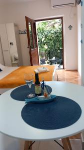 una mesa con una copa de vino y una botella de vino. en Apartment Cattaro magico en Kotor