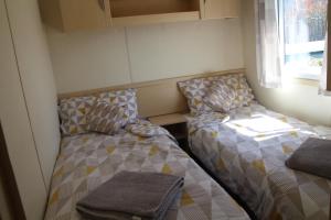 Cette petite chambre comprend 2 lits et une fenêtre. dans l'établissement Lovely and friendly Mobile Home in Gassin France, à Gassin