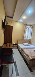 Un dormitorio con 2 camas y una silla. en Almeto Hotel, en Tiflis