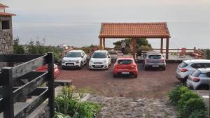 a group of cars parked in a parking lot near the ocean at Sara Village in São Roque do Pico