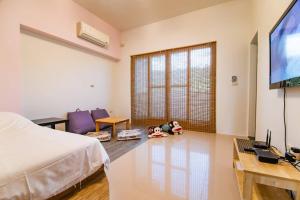 a bedroom with a bed and a child laying on the floor at Wind Breathing B&B in Toucheng