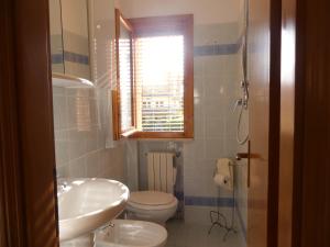 bagno con lavandino, servizi igienici e finestra di Villetta Puccini a Lido Adriano a Ravenna