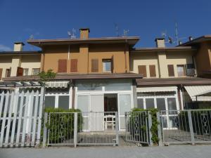 una casa con una recinzione bianca davanti di Villetta Puccini a Lido Adriano a Ravenna