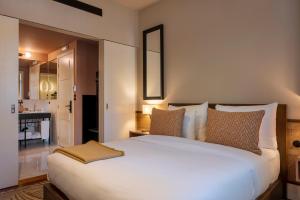 a bedroom with a large white bed and a bathroom at Casa da Marechal - Boutique Hotel by Oporto Collection - Adults Only in Porto