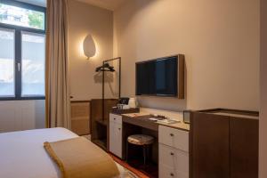 a hotel room with a bed and a desk with a television at Casa da Marechal - Boutique Hotel by Oporto Collection - Adults Only in Porto