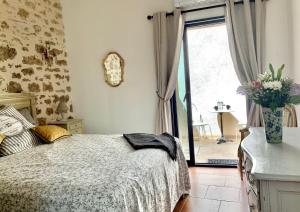 a bedroom with a bed and a window and a vase of flowers at La Posada Townhouse with Private Parking in Pézenas