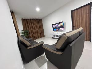 two chairs in a living room with a tv at Armadale Residence-Gala City in Kuching