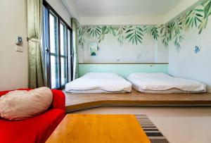 1 dormitorio con 1 cama y 1 sofá rojo en Wind Breathing B&B en Toucheng