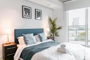 a bedroom with a large bed with a blue headboard at Khayat Homes - The Curve - One Bed in London