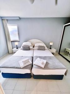 a bedroom with two beds and two lamps and a mirror at Atlantic Gardens Beach - atlanticgardensbeach com in Funchal +43 photos