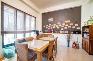 a dining room with a wooden table and chairs at Wind Breathing B&B in Toucheng