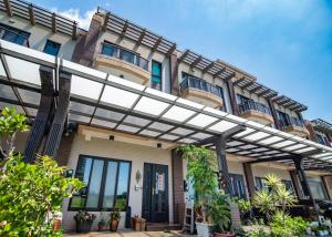 un edificio con una pérgola delante de él en Wind Breathing B&B, en Toucheng