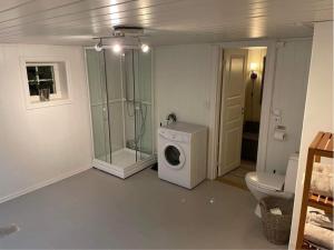 a bathroom with a washing machine and a shower at Koselig hus på gård med 6 soverom in Gran