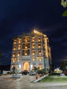 un edificio de hotel con coches aparcados en un aparcamiento en Satyam Palace Resort, en Pushkar