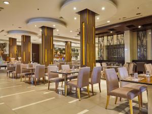 a dining area with tables and chairs in a restaurant at Maple Hotel in Bangkok