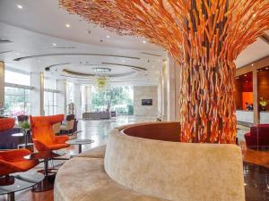 a lobby with a large fountain with a tree in it at Maple Hotel in Bangkok