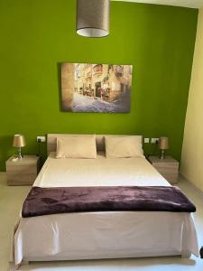 zielona sypialnia z dużym łóżkiem z 2 lampami w obiekcie Sunset Apt Modern 1 bedroom Apt near the Beach w mieście Birżebbuġa