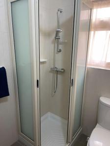 La salle de bains est pourvue d'une douche avec une porte en verre. dans l'établissement Sunset Apt Modern 1 bedroom Apt near the Beach, à Birżebbuġa