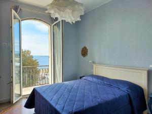 um quarto com uma cama azul e uma grande janela em Casa Ortensia em Albissola Marina