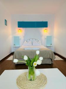 a bedroom with a bed and a vase of flowers on a table at Vila Primavera in Vama Veche