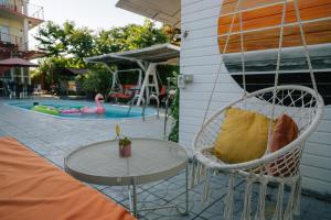 een patio met een tafel en stoelen en een zwembad bij Vila Primavera in Vama Veche