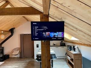 een flatscreen-tv op een paal in een keuken bij Au Cocon du Haut Pergé in Gérardmer
