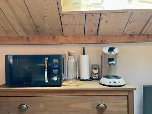 een magnetron bovenop een houten aanrecht bij Au Cocon du Haut Pergé in Gérardmer +3 foto's