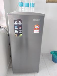 a grey refrigerator with water bottles on top of it at Muslim Nur Homestay in Kepala Batas