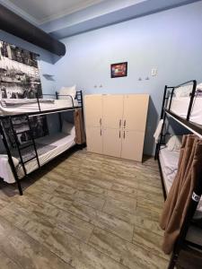 een kamer met 2 stapelbedden en een houten vloer bij Tbil Home Hostel in Tbilisi City