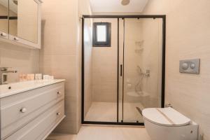a bathroom with a shower with a toilet and a sink at Sea Valley Lodge in Faralya