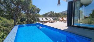 a swimming pool with lounge chairs on a house at Casa Blanca in L'Escala