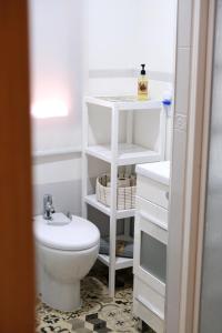 a white bathroom with a toilet and a sink at Slappe Jaén II in Jaén
