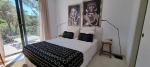 a bedroom with a bed with two pictures on the wall at Casa Blanca in L'Escala +16 photos