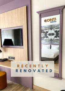 a mirror in a hotel room with a sign that reads recently renovated at CONTI HOTEL VILNIUS, Conference Centre, Restaurant & Bar in Vilnius