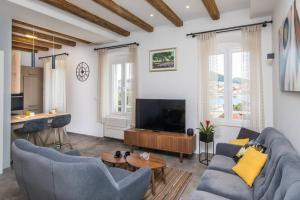 a living room with a couch and a tv at Apartment MIAMAR with port sea view in Dubrovnik