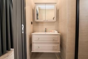 a bathroom with a white sink and a mirror at Sea Valley Lodge in Faralya