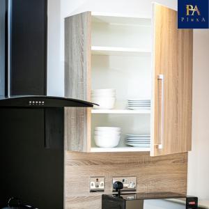 a kitchen with a cupboard with dishes in it at Pluxa Mint Bliss - Stylish with workspace in Birmingham