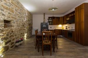 a kitchen with a table and a stone wall at Appartamenti Gli Ippocastani in San Benedetto Belbo +16 photos