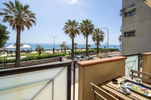 馬薩奧的住宿－The Magic Place，阳台享有大海和棕榈树的景致。